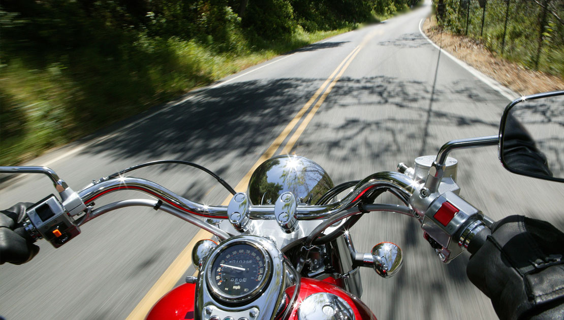View from the driver's seat of a motorcycle going down a winding highway