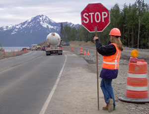 Woman holding stop sign at construction zone