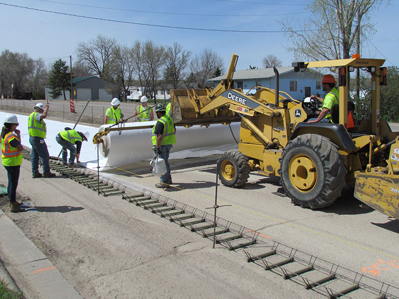 Crew using tractor to lay Bondbreaker fabric