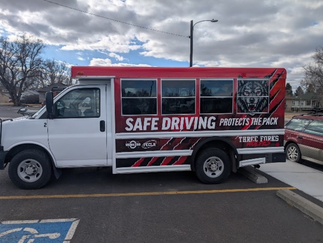 Bus with new vehicle wrap that says Safe Driving Protects the Pack